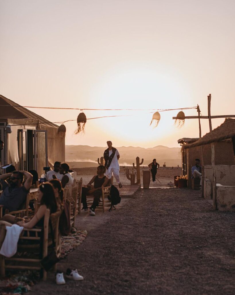 Agafay Desert camp, towering cliffs, Agafay Desert, Marrakech, Scenic view of golden sand dunes and barren landscape in Agafay Desert, Morocco.
